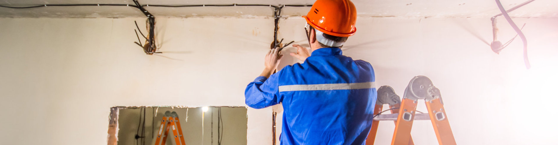 man in safety helmet monitoring electric wirings