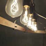 Close-up of warm Edison-style pendant bulbs on wooden fixture — soft ambient glow